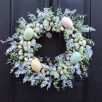 Easter wreath with pastel eggs and greenery on a dark door