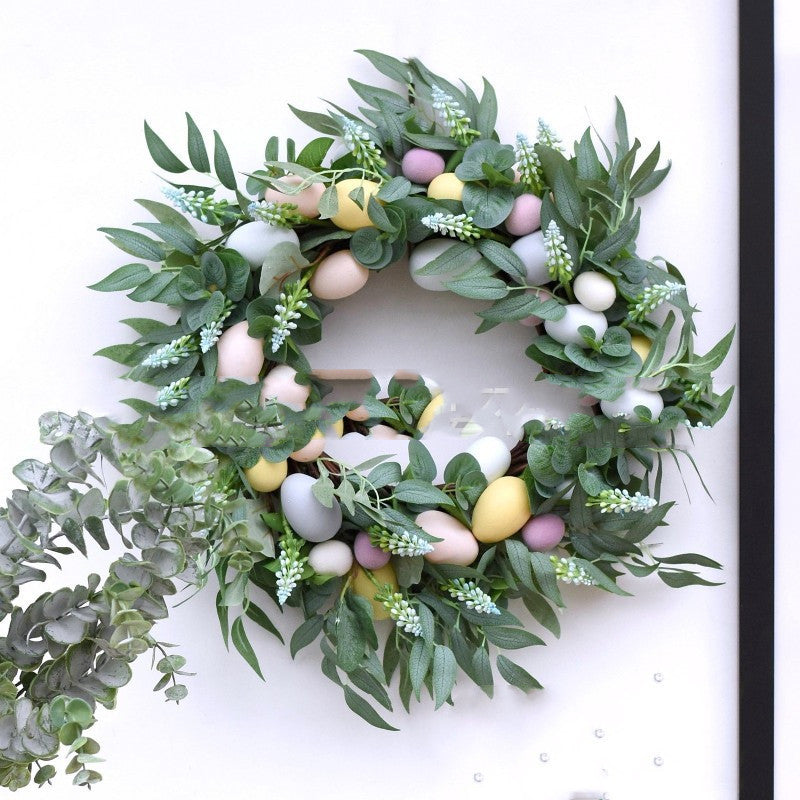 Easter wreath with pastel eggs and greenery on a white background