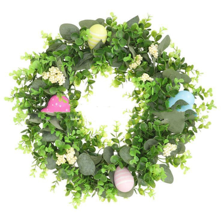 Green leafy wreath with colorful eggs on a white background