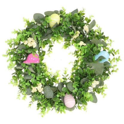 Green leafy wreath with colorful eggs on a white background